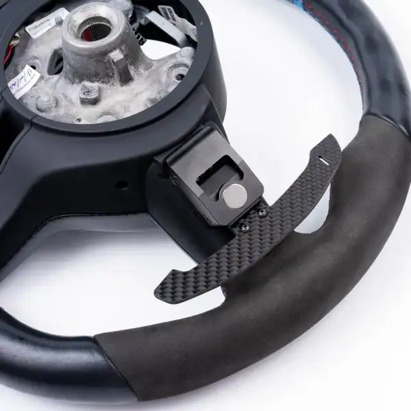 BMW carbon fiber magnetic paddle shifter installed on Alcantara steering wheel interior detail